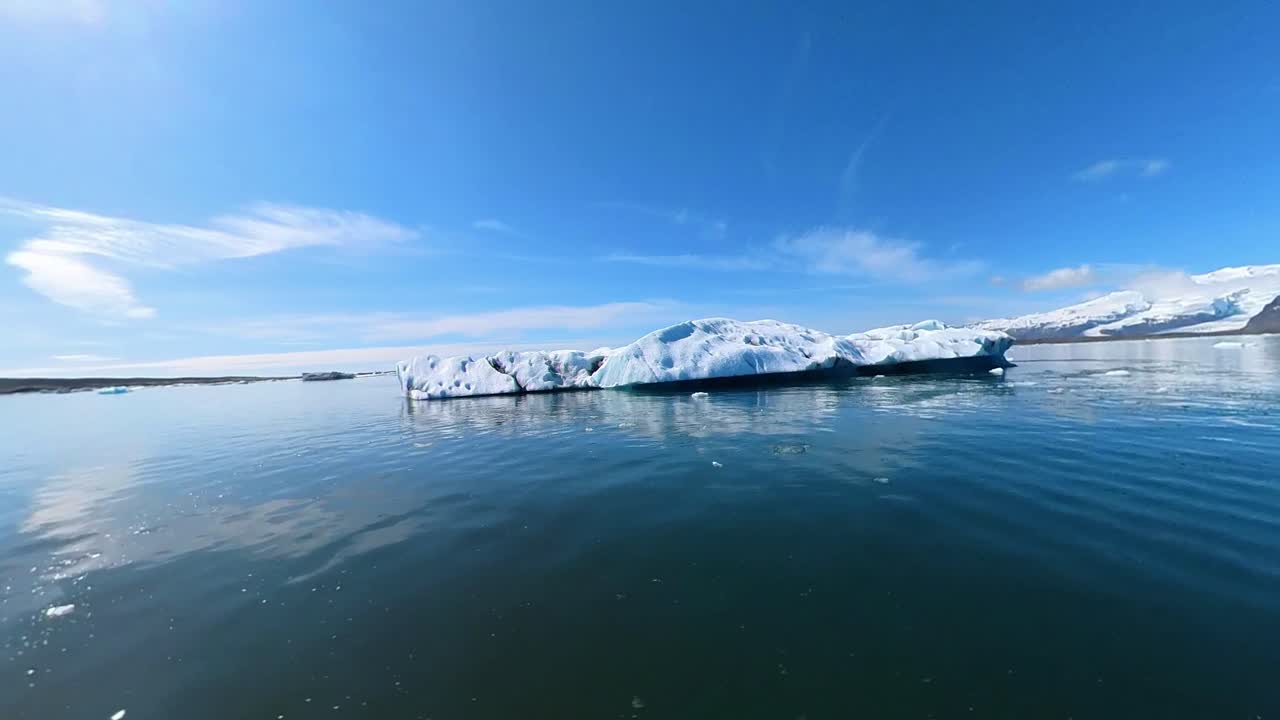 아이슬란드의 경이로운 아름다움, 거대한 빙산들이 은 푸른 하늘에서 반이는 빛 아래 게으르게 떠다니는 곳.