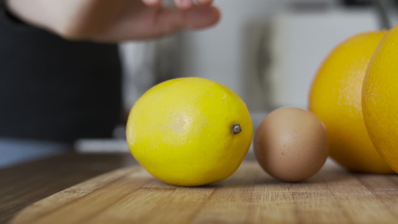 Slow motion as taking, picking up a lemon in the kitchen