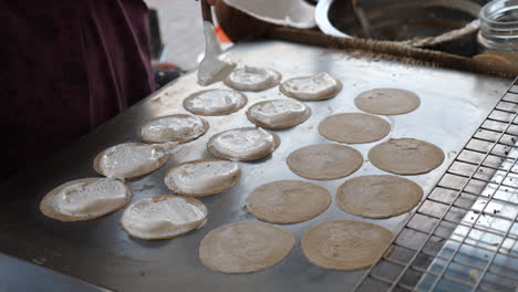 vendedor de comida callejera tailandesa haciendo un famoso panqueque crujiente tailandés