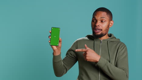 Portrait-of-man-doing-influencer-marketing-using-green-screen-phone