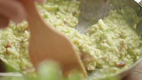 cocinero de cultivos mezclando risotto caliente en una sartén