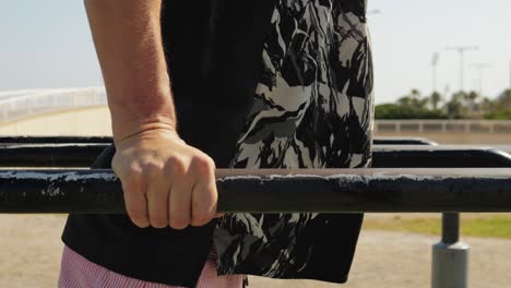 Man doing handstand on parallel bars outdoors