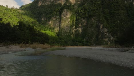 Drone-flying-at-low-altitude-over-water-surface-of-Muchas-Aguas-river,-San-Cristobal-in-Dominican-Republic