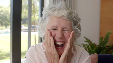 Portrait-of-happy-senior-caucasian-woman-making-video-call-at-home,-unaltered,-in-slow-motion