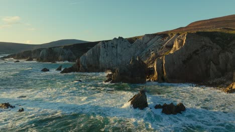 Grandes-Olas-Golpeando-Los-Acantilados-De-La-Isla-Achill-Durante-La-Puesta-De-Sol,-Disparo-De-Drones