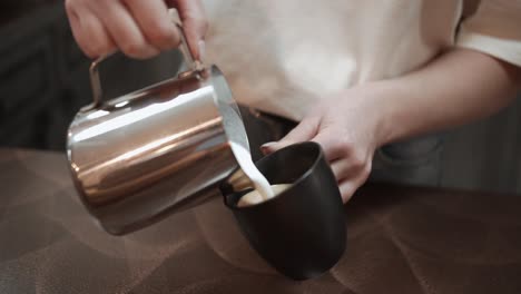 Bartender-pouring-hot-milk-into-coffee-in-restaurant,-real-time-close-up