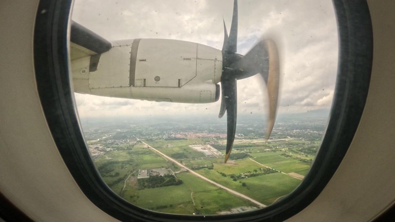 Airplane propeller slows down during descent seen from window Coron Philippines