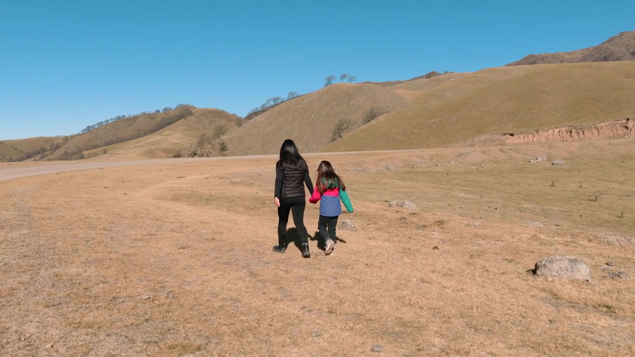 Vista drone di madre e figlia che camminano attraverso Quebrada del Portugues vicino a Tafi del Valle, Tucuman, Argentina
