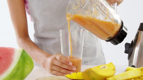 Mittelteil-Einer-Frau,-Die-Smoothie-In-Ein-Glas-Gießt