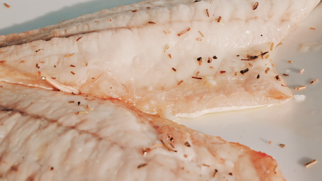 Close up of a freshly grilled white fish fillet seasoned with herbs