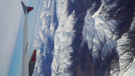 vertical video of an airplane wing over new zealand mountains