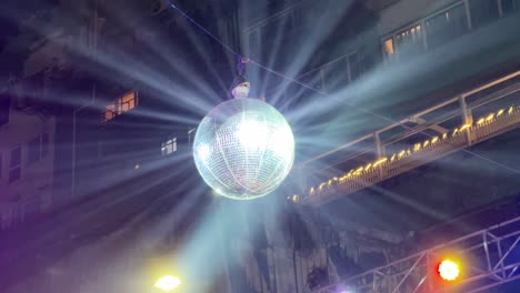 low angle view of a bright disco ball reflecting laser lights on roads of park street on christmas night in kolkata, india.