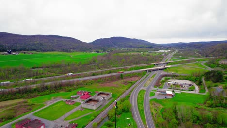 Epic-aerial-of-Semi-trucks-on-I-80-interstate-in-Milesburg-Pennsylvania,-USA