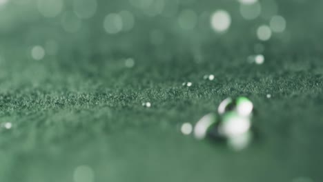 Micro-video-of-close-up-of-water-drops-with-copy-space-on-green-background