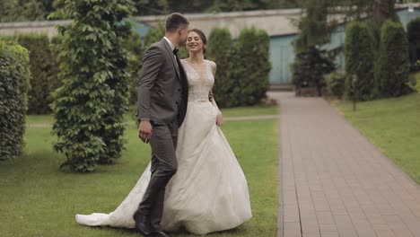 Lovely-newlyweds-caucasian-bride-groom-walking-in-park,-holding-hands,-wedding-couple-family