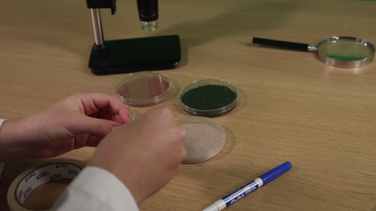 manos preparando muestras de suelo con etiquetas y herramientas