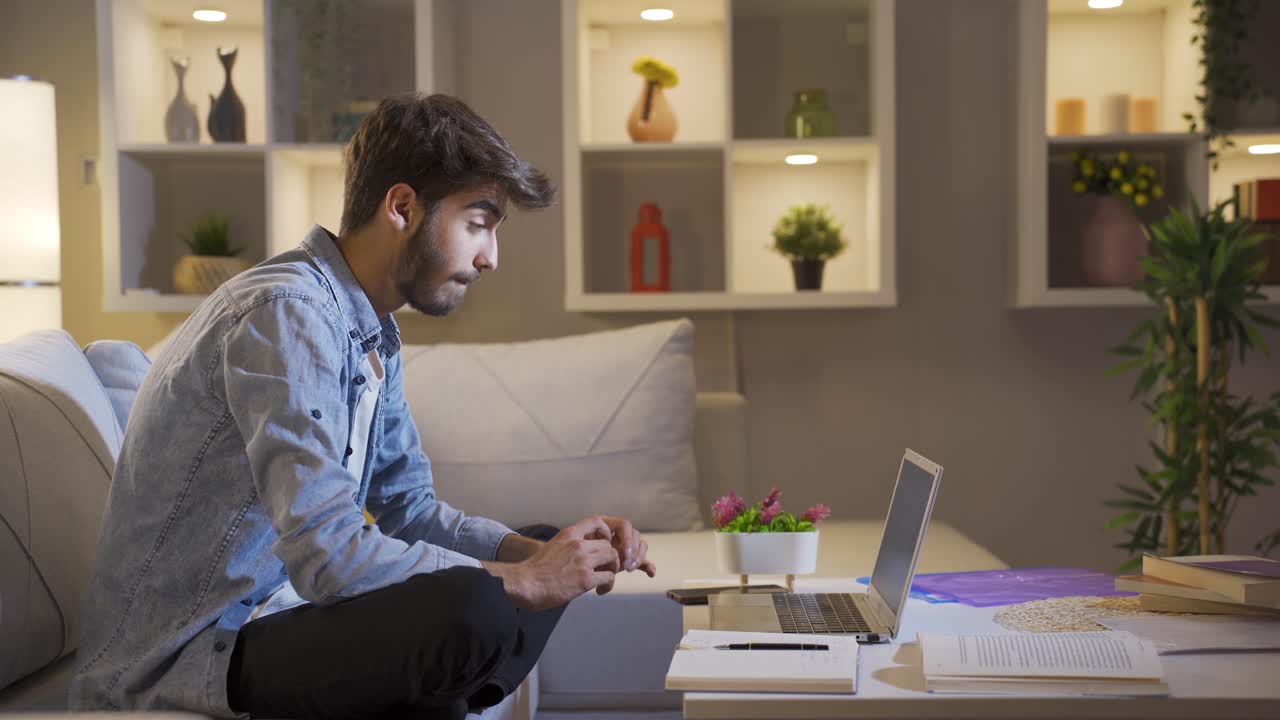 hombre viendo una película en la computadora portátil por la noche.