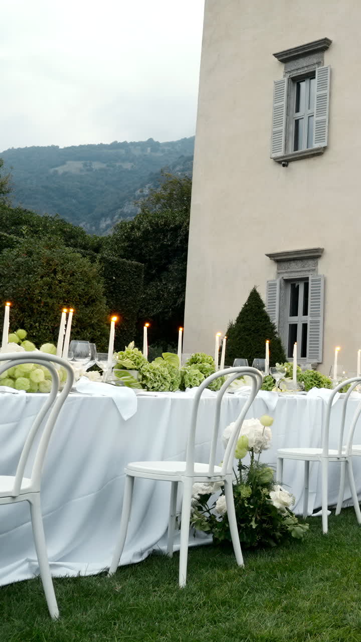 Elegant Outdoor Table Setting with Candles and White Chairs