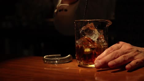 sequence of stirring whiskey with ice in a glass