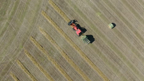 Vista-Aérea-De-Pájaro-Del-Tractor-Haciendo-Pacas-De-Heno-En-El-Campo