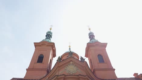 exterior of church of saint lawrence with two bell towers in prague, czech republic