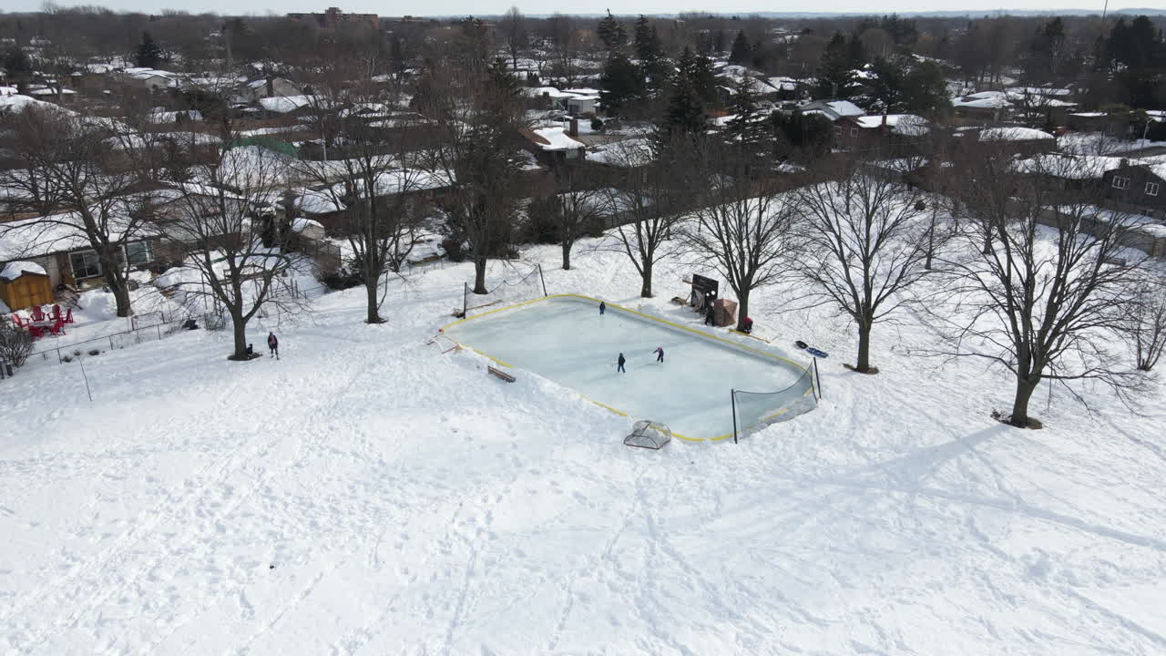 Tři bruslaři se učí lední hokej v parku Walker's Creek v Catharines, Ontario