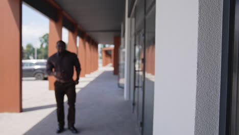 black man standing in city street. black man in suit walking on the street in the background