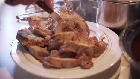 Close-up-on-man's-hands,-cutting-cooked-chicken-roll-at-home,-hot-and-steamy