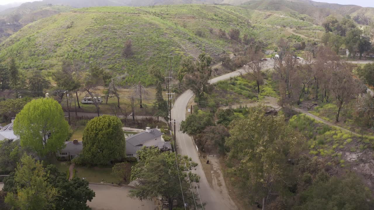 Aerial low shot flying over the road into Will Rogers State Historic Park after the fire in Pacific Palisades, California. 4K