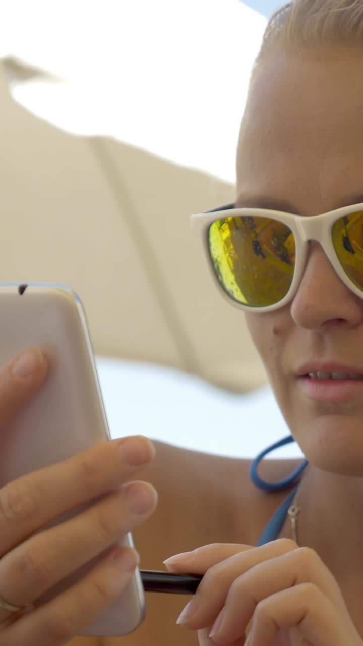 Woman using mobile phone on the beach