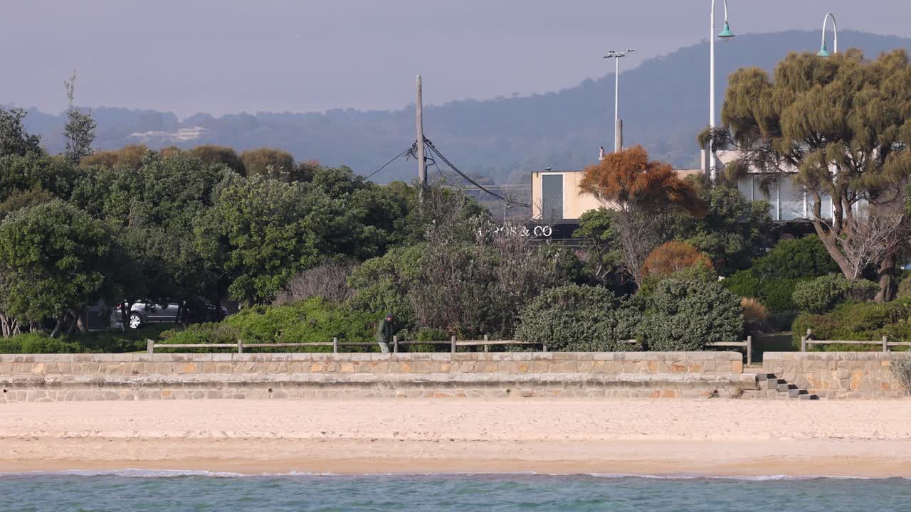 드로마나 의 해변 벽 을 따라 고 있는 남자