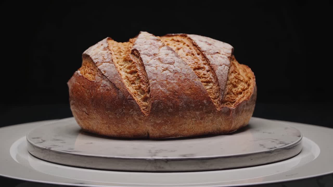 Close-up video of artisanal bread on a marble plate, shot from a low angle