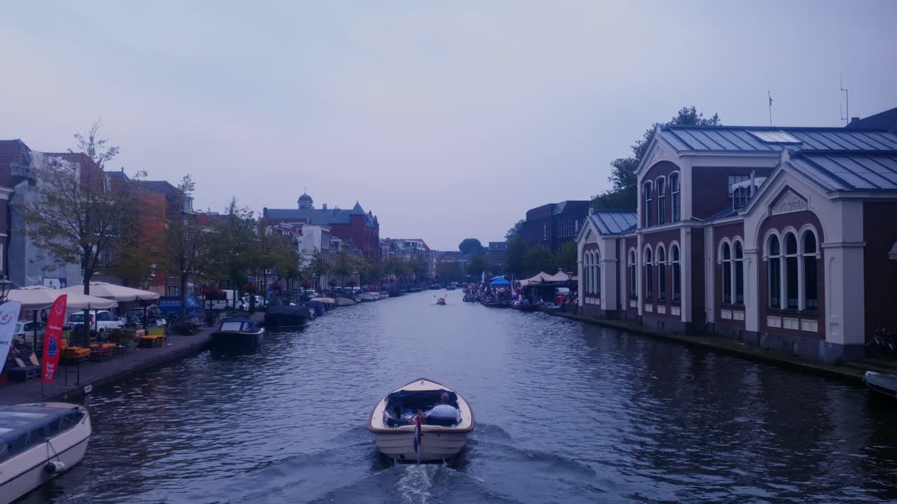 View of boat sailing from under bridge in canal in Leiden