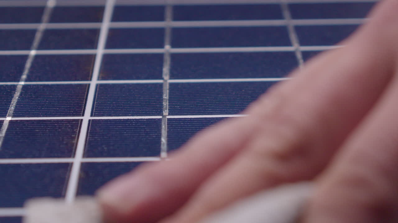 클로즈업 뷰: 청소 천으로 손을  ⁇ 는 파란 타일 카운터  ⁇