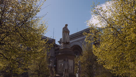 leonardo da vinci statue during sunny day in piazza della scala, milan, italy