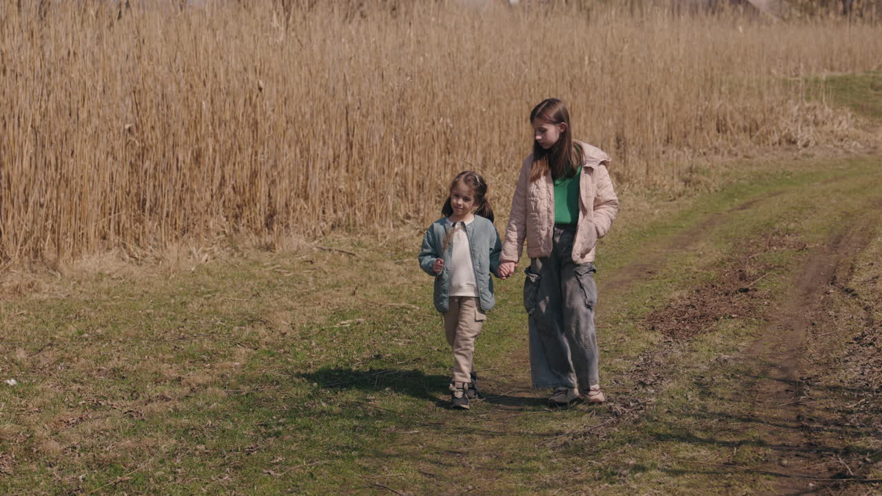 Twee zussen wandelen in een veld
