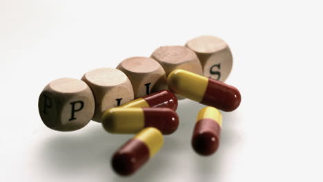 cápsulas de medicina cayendo delante de los dados pastillas de ortografía