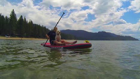 un hombre y un perro remando en el lago tahoe 1