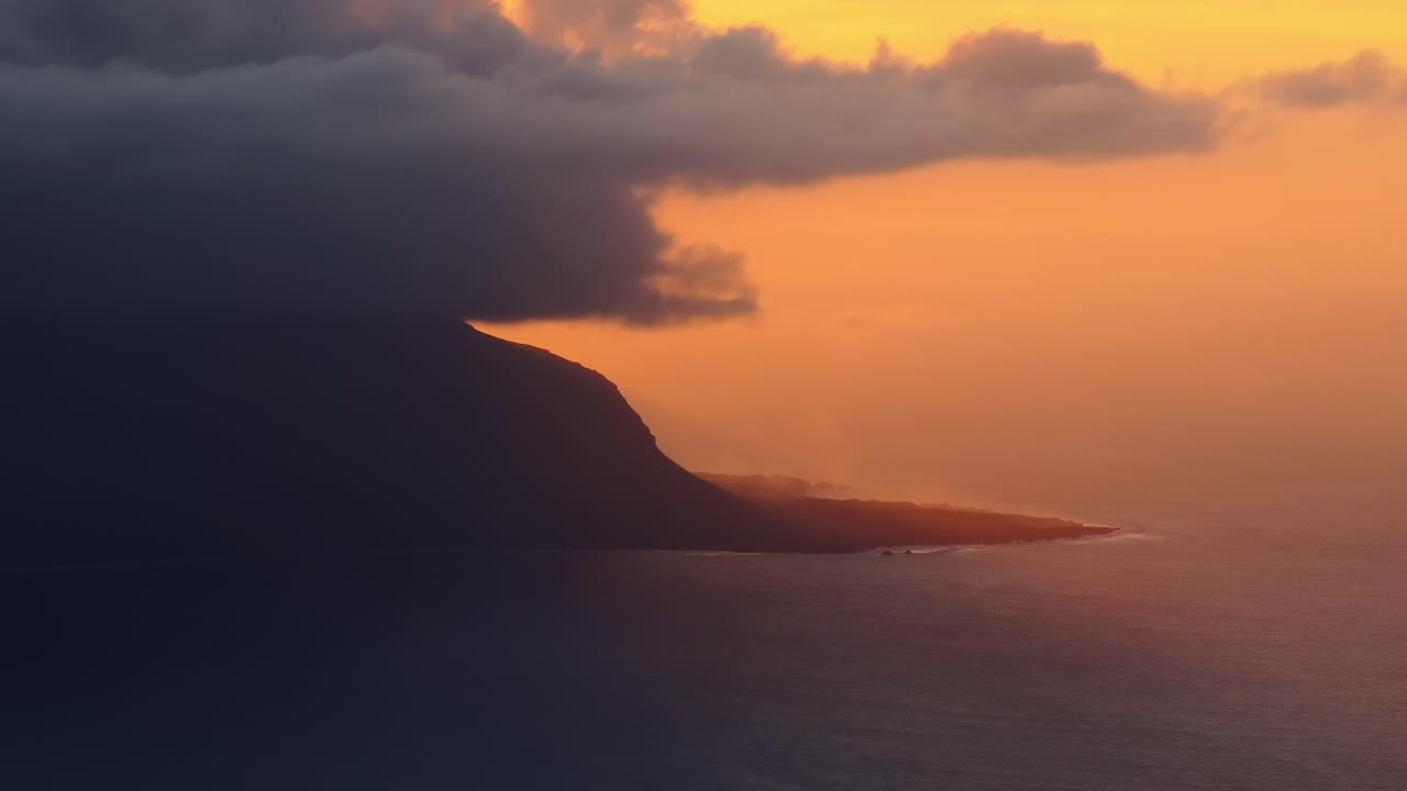 Dramatic sunset light over El Hierro’s coastline as heavy clouds volcanic cliffs
