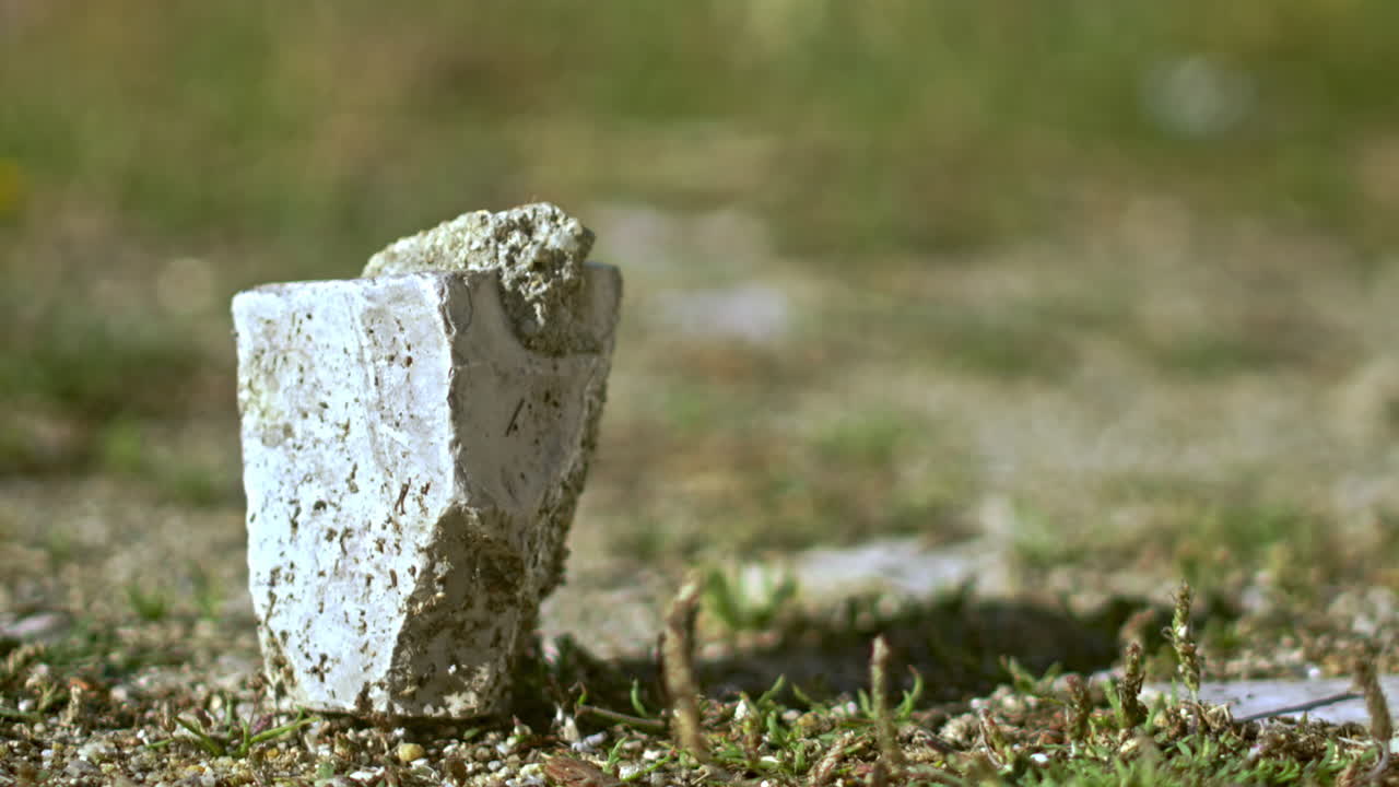 A square rock on the ground.