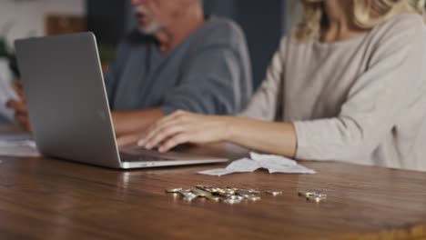 mujer caucásica con un hombre mayor comprobando las finanzas del hogar en documentos y computadora portátil.