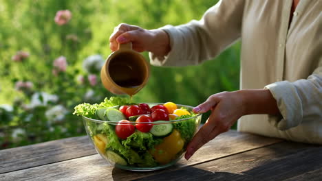 preparing a fresh garden salad with dressing outdoors