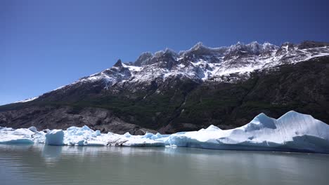 lago glaciar con una montaña con nieve en los picos en el fondo, disparo estático