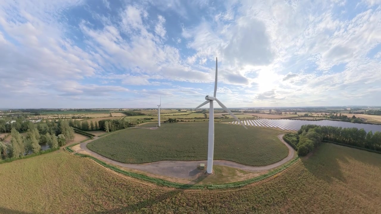 aerial drone footage, Sunset view over a field of renewable energy sources featuring wind turbines and natural scenery. Lincolnshire solar panel arrays wind turbines countryside, England