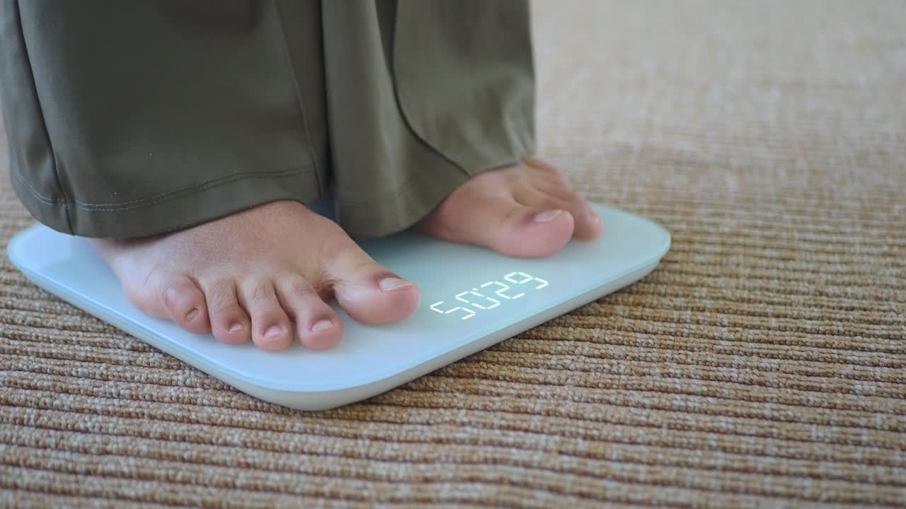 Person's Bare Feet Standing on a Digital Weighing Scale