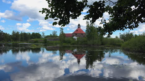 A-large-body-of-water-and-green-foliage-enlarging-the-charms-of-Museum-fortress-Korela,-Russia