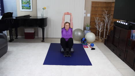 woman performing cool down after fitness session in home gym, static