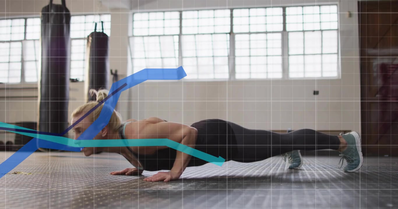Doing woman starting plank, lowering and pushing up on rubber floor for strength wearing dark tank