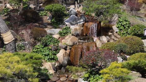 a serene waterfall flows through a lush garden