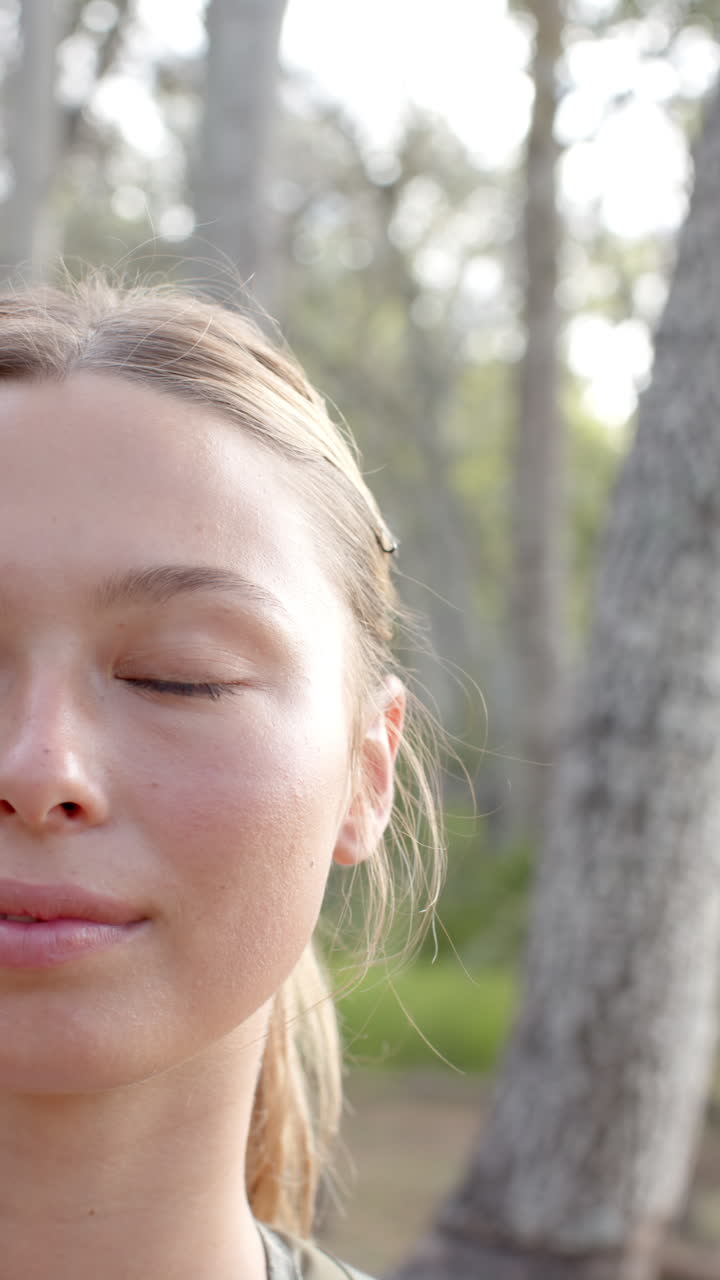 Vertical video: Close-up of woman hiking in forest, enjoying nature and fresh air